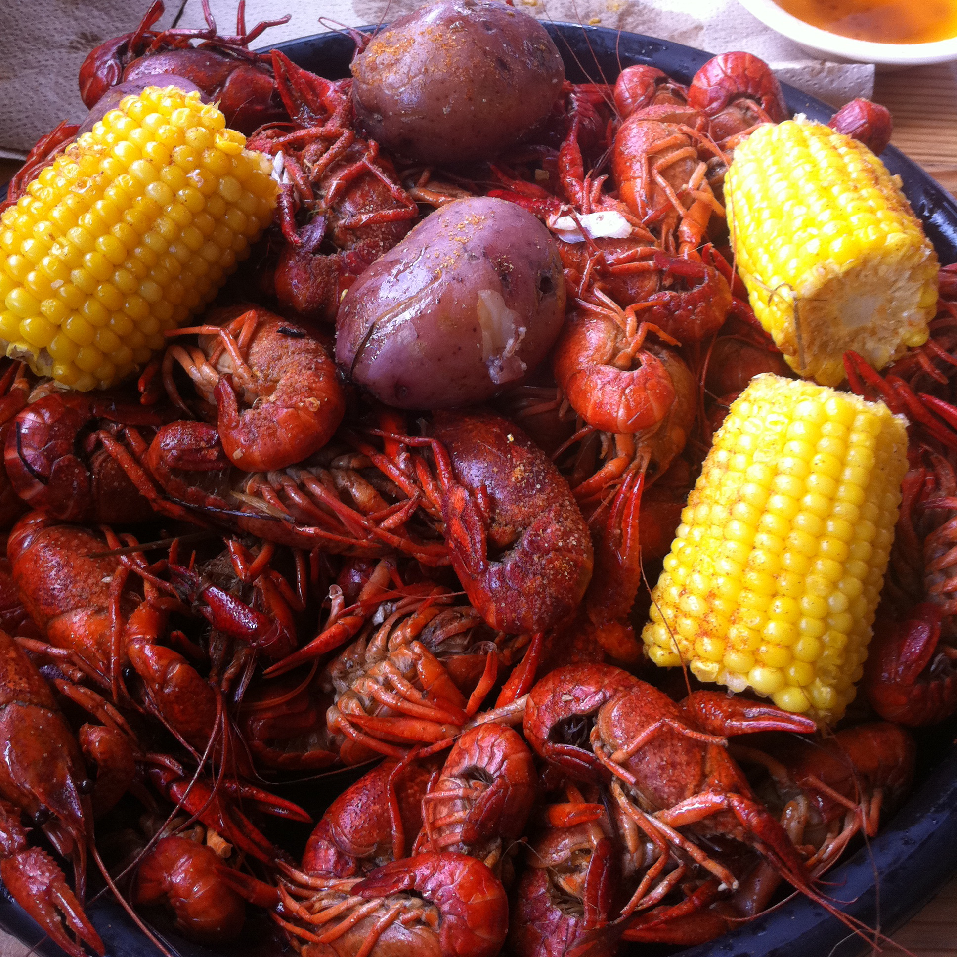 A crawfish boil spread with corn and potatoes on paper